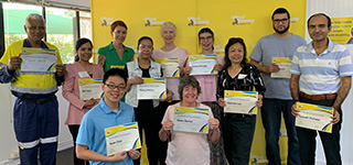 Good Sammy volunteers holding their certificates and smiling at the camera