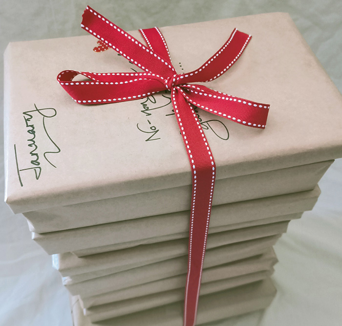 Books neatly wrapped in recycled brown paper with handwritten description of what's inside.