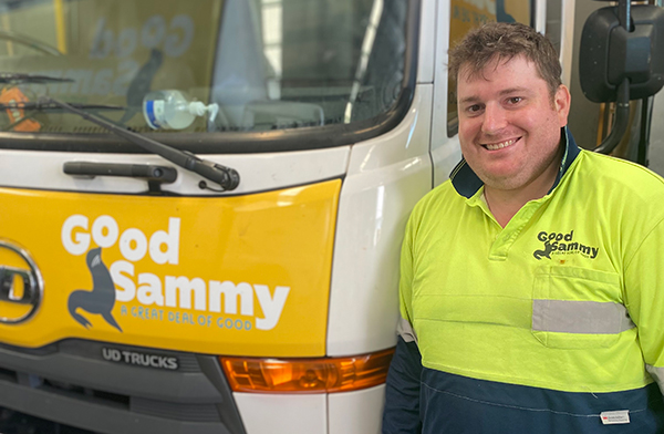2021 Employee of the Year, Sam Cooper, standing next to a truck and smiling at camera.