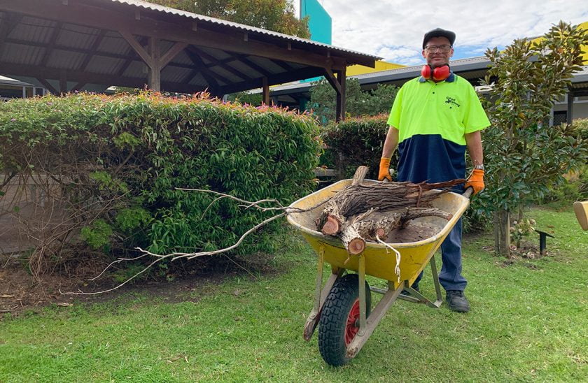 Good Sammy Property Care employee, Arthur, with wheelbarrow and smiling at camera.