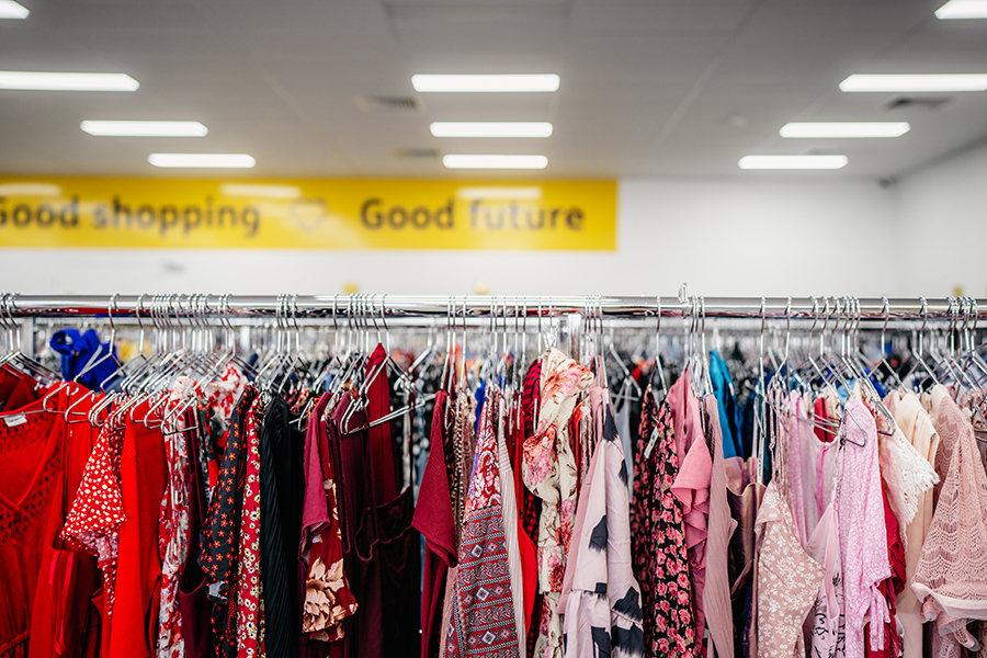 Preloved clothing hanging on racks in store